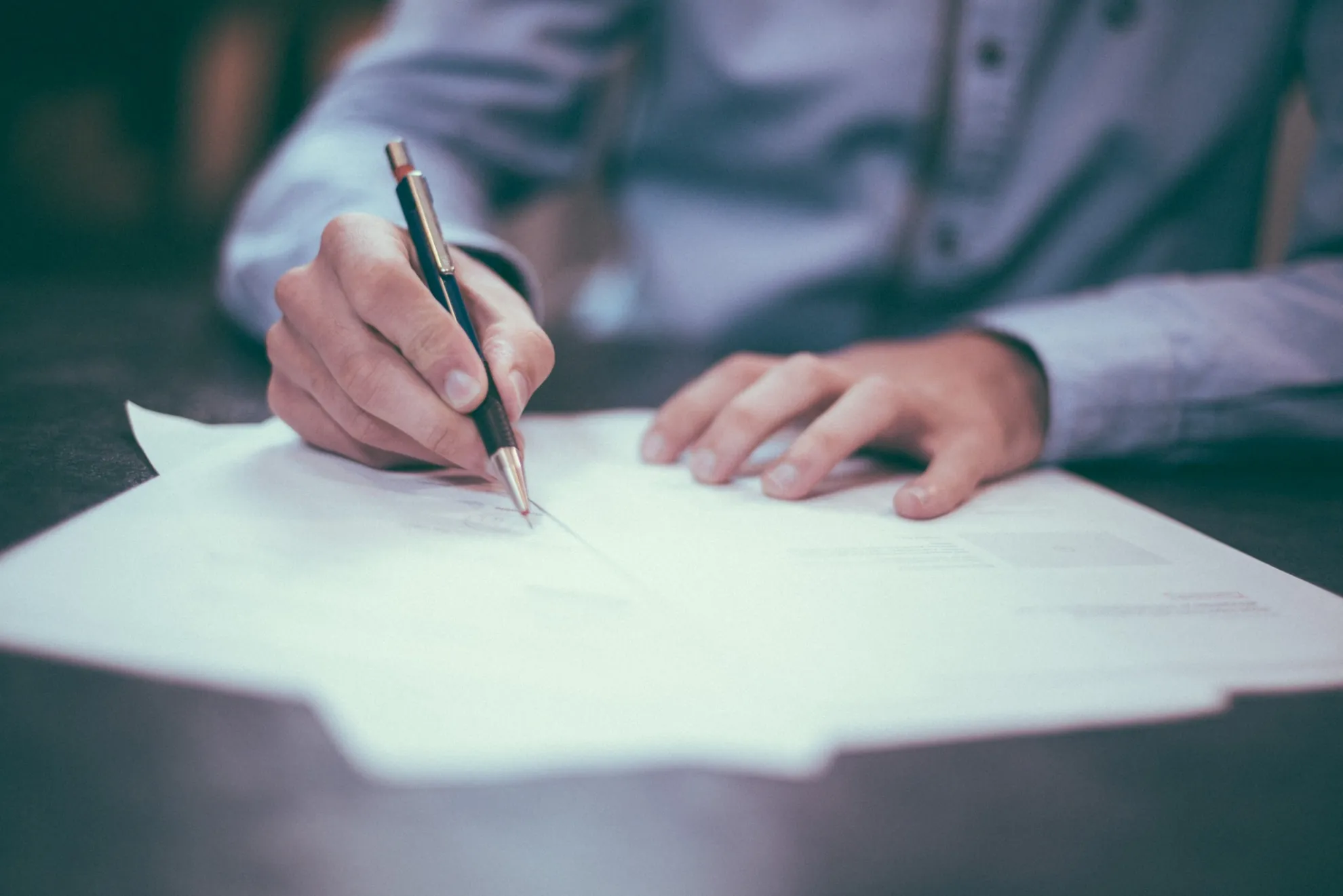 Underwriter signing an insurance policy document